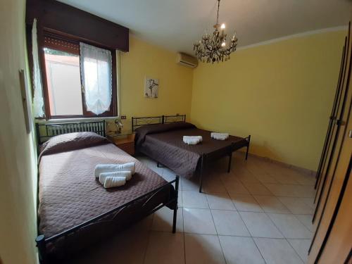 1 dormitorio con 2 camas, mesa y lámpara de araña en Sleeping Beauty, en Chiari