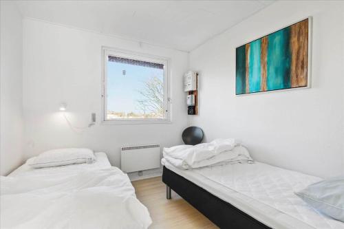 two beds in a white room with a window at 6785-Allinge-Tejnvej-92 in Allinge
