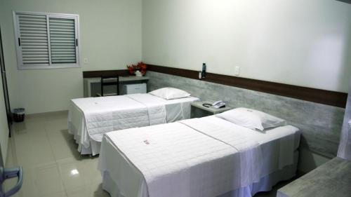a hospital room with two beds and a table at Tezla Hotel in Primavera do Leste