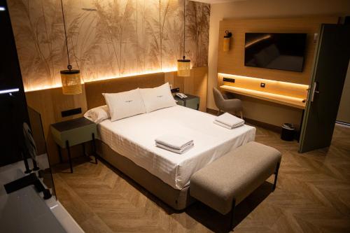 a bedroom with a bed and a desk and a television at Hotel Macami in El Carpio