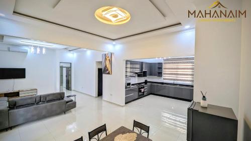 Una sala de estar con un sofá y un televisor. en Mahanaim Luxury apartments, en Lusaka