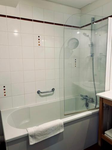 a bathroom with a shower and a tub and a sink at La Renaudière in Isbergues