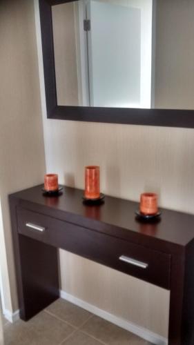 a bathroom vanity with two orange candles and a mirror at Departamentos Rohe in Puerto Montt