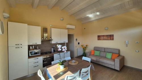 a kitchen and living room with a table and a couch at La Pergola del Kiwi a Pitigliano in Pitigliano