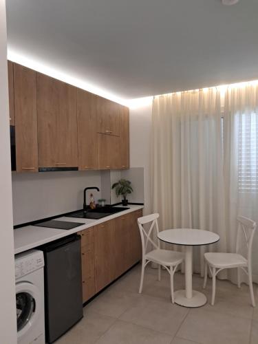 a kitchen with a table and a table and chairs at Apartments Keesi 1 in Durrës