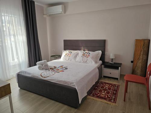 ein Schlafzimmer mit einem großen Bett und einem roten Stuhl in der Unterkunft Mishel apartment Shkoder in Shkodra