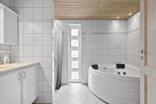 a white bathroom with a tub and a sink at 3517-Nexo-Turistvej-47-B in Neksø