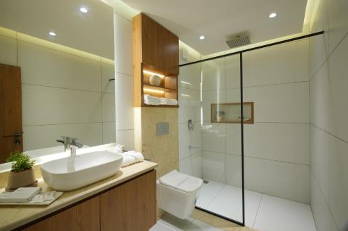 a bathroom with a sink and a toilet and a shower at Contemporary Serviced Apartment in Kolencherry in Kadayirippu
