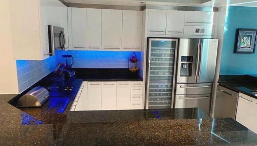 a kitchen with white cabinets and a stainless steel refrigerator at High-Rise Two-Bedroom Condo with Panoramic City Views in Las Vegas
