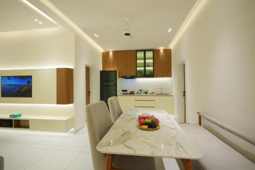 a kitchen and dining room with a table and chairs at Contemporary Serviced Apartment in Kolencherry in Kadayirippu