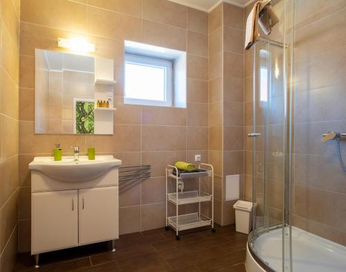 een badkamer met wastafel en douche bij Avanti Apartman - Avanti Tutti in Balatonboglár