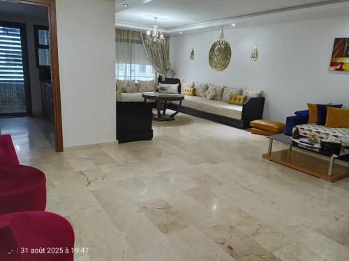 a living room with a couch and a table at Appart Haut Standing, Très Calm à Nouaceur, Parking, Piscine, à 4min de l'Aéroport in Casablanca