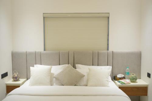 a bedroom with a large bed with white pillows at Contemporary Serviced Apartment in Kolencherry in Kadayirippu
