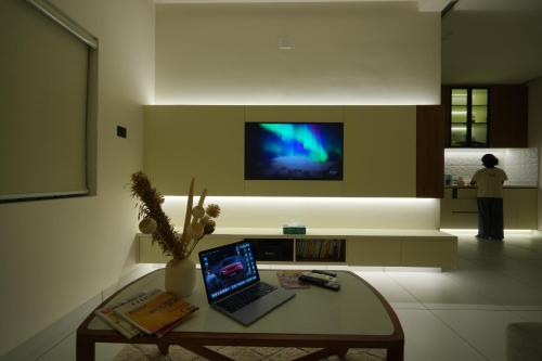 a living room with a table with a laptop on it at Contemporary Serviced Apartment in Kolencherry in Kadayirippu
