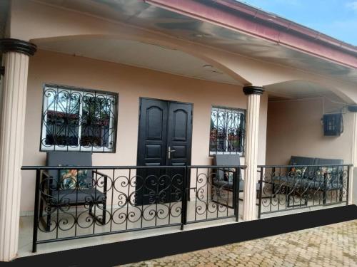 a balcony of a house with black doors and chairs at Appart Ker L'AM in Lada