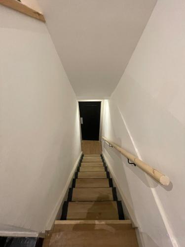 a hallway with stairs leading to a dark room at The greenfield hideaway in Greenfield