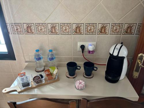 a counter top with a coffee maker and water bottles at Casa Azacanes in Sanlúcar de Barrameda
