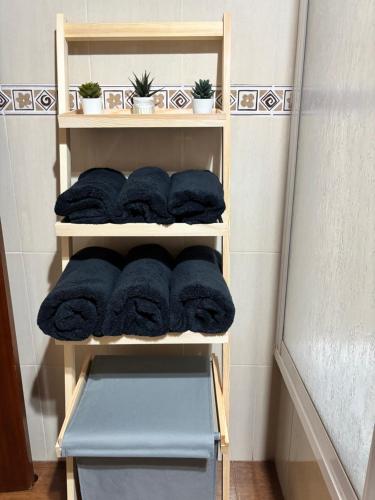 a wooden shelf with towels in a bathroom at Casa Azacanes in Sanlúcar de Barrameda