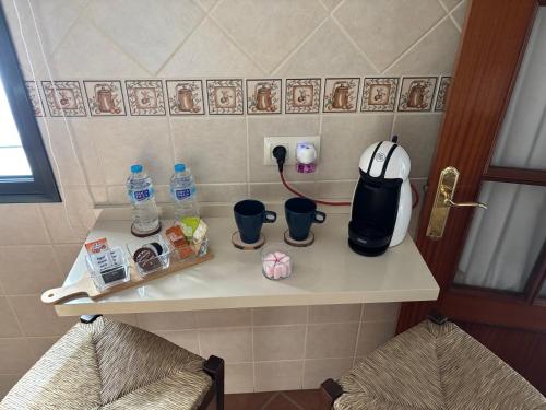 a kitchen counter with a coffee maker and two chairs at Casa Azacanes in Sanlúcar de Barrameda