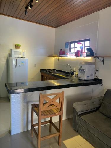 a kitchen with a counter and a chair in a room at 07 Apartamento com vista para a montanha in São Sebastião