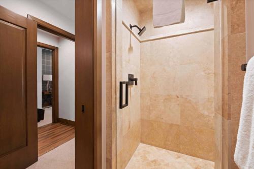 a bathroom with a shower with a glass door at Village Hall 13 by East West Hospitality in Beaver Creek