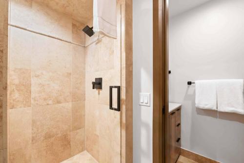 a shower with a glass door in a bathroom at Village Hall 13 by East West Hospitality in Beaver Creek