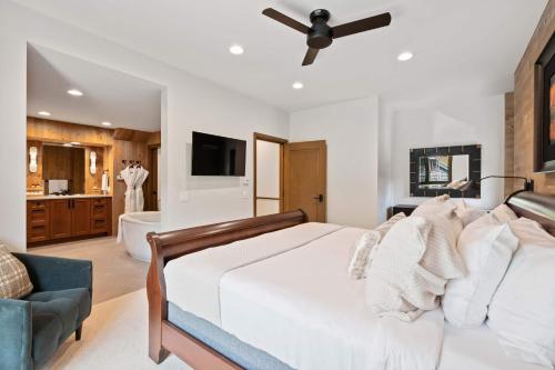 a bedroom with a white bed and a bathroom at Village Hall 13 by East West Hospitality in Beaver Creek
