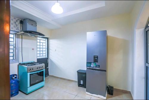 a kitchen with a stove and a refrigerator in it at Villa luxueuse Gefona Guest HOUSE in Yaoundé