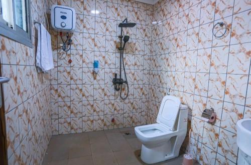 a small bathroom with a toilet and a sink at Villa luxueuse Gefona Guest HOUSE in Yaoundé