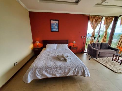 a bedroom with a bed and a couch and a chair at Beautiful view suite Suite vista hermosa in Macas