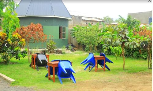 a group of tables and chairs in front of a house at ndugu gardens kasese guest house in Kasese