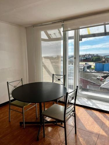 a table and chairs in a room with a view of an airport at Bocamar Aparthotel in Viña del Mar