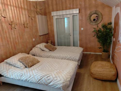 two twin beds in a room with a mirror at Bel Horizon in Saint-Jean-Froidmentel