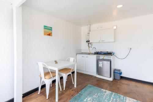 a kitchen with a white table and chairs in a room at Bocamar Aparthotel in Viña del Mar