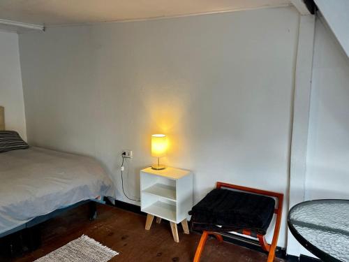a small bedroom with a bed and a lamp on a night stand at Bocamar Aparthotel in Viña del Mar