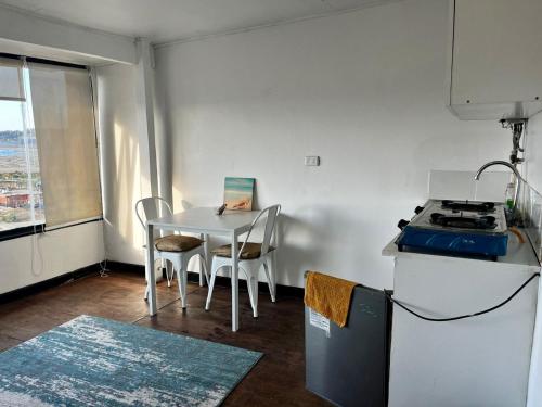 a kitchen with a table and a table and chairs at Bocamar Aparthotel in Viña del Mar