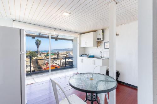 a kitchen and dining room with a table and a window at Bocamar Aparthotel in Viña del Mar