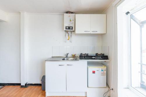 a kitchen with white cabinets and a sink at Bocamar Aparthotel in Viña del Mar