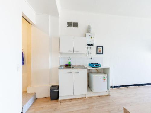 a white kitchen with a sink and a refrigerator at Bocamar Aparthotel in Viña del Mar