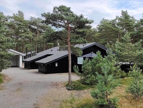 a black house in the middle of a forest at 2512-Nexo-Rokjinkan-7 in Vester Sømarken