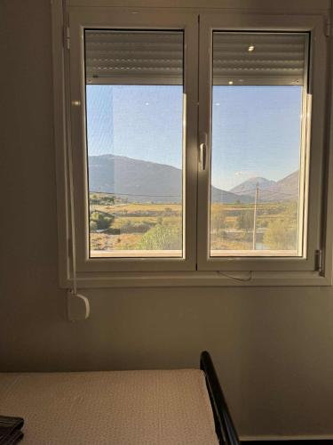 a bedroom with a window with a view of the mountains at Old Castle Location in Gjirokastër