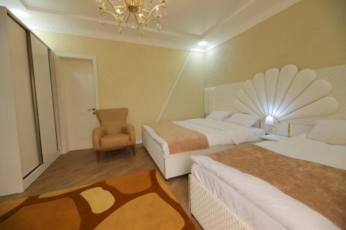 a hotel room with two beds and a chair at Hotel Harmony Premium in Kutaisi