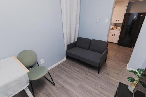 a living room with a couch and a chair at Avenir Centre Suite - Near NBCC - Large Garden in Moncton