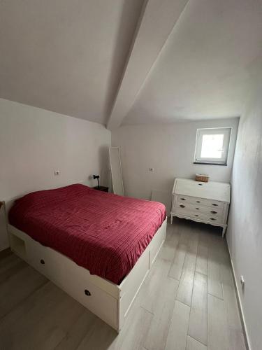 a white bedroom with a bed and a window at Casa da Armada in Magoito