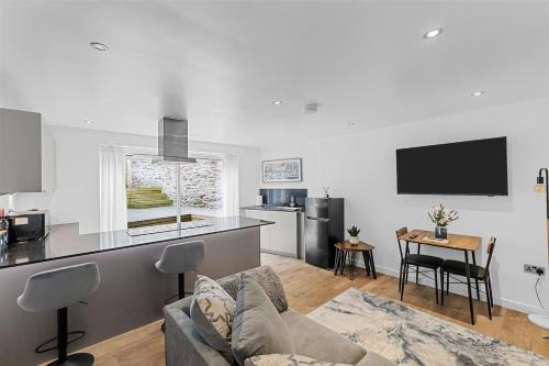 a living room with a couch and a kitchen at 1 Bed Stylish Central Apartment - Barbican Plymouth in Plymouth