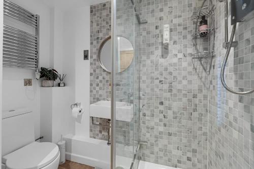 a bathroom with a shower with a sink and a toilet at 1 Bed Stylish Central Apartment - Barbican Plymouth in Plymouth
