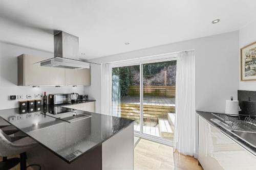 a kitchen with a black counter top and a window at 1 Bed Stylish Central Apartment - Barbican Plymouth in Plymouth