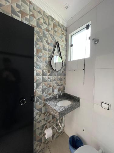 a bathroom with a sink and a mirror at Hotel Carmelita in Aparecida
