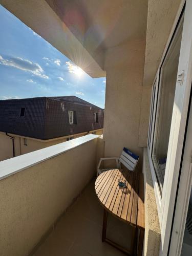 a balcony with a wooden table and a window at Divine Studio Fermei 62 in Popeşti-Leordeni