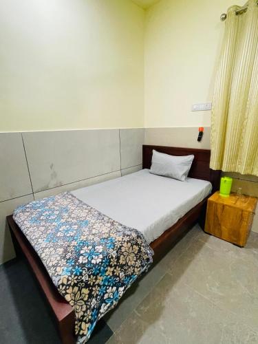 a bedroom with a bed with a blanket on it at Mp DREAMS ROOMS in Edappāl